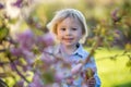 Little toddler boy, eating chocolate bunny in garden on sunset, easter eggs Royalty Free Stock Photo