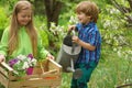 Little toddler boy and girl gardening and having fun in spring yard. Pretty cute kids working and playing in beautiful