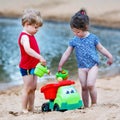 Little toddler boy and girl playing together with sand toys near Royalty Free Stock Photo