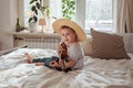 Little toddler boy in hat playing ukulele guitar at home, rustic style. Lifestyle concept Royalty Free Stock Photo