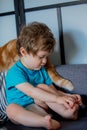 Toddler boy hold his foot after playing with a cat Royalty Free Stock Photo