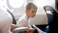 Little toddler boy holding by hand his mother during first flight in airplane Royalty Free Stock Photo