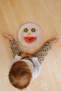 Little toddler boy and imrovised fruit face dinner on a plate Royalty Free Stock Photo