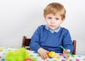 Little toddler boy painting colorful eggs for Easter hunt Royalty Free Stock Photo