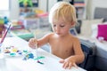 Little toddler boy, painting at home, learning coordination of moves Royalty Free Stock Photo