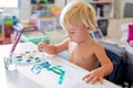 Little toddler boy, painting at home, learning coordination of moves Royalty Free Stock Photo