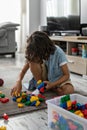 Little toddler boy playing with colorful plastic blocks at home building creative game, imagination