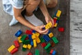 Little toddler boy playing with colorful plastic blocks at home building creative game, imagination