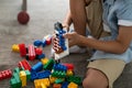 Little toddler boy playing with colorful plastic blocks at home building creative game, imagination