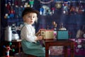 Little toddler boy, playing with mill at home, sitting on vintage table Royalty Free Stock Photo