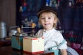 Little toddler boy, playing with mill at home, sitting on vintage table Royalty Free Stock Photo