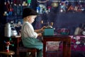 Little toddler boy, playing with mill at home, sitting on vintage table Royalty Free Stock Photo