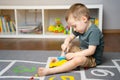 A little toddler boy is playing with a toy helicopter, assembling and disassembling it. Royalty Free Stock Photo