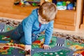 Little toddler boy playing with wooden railway, indoors. Happy cute child moving trains at home or daycare. Lifestyle Royalty Free Stock Photo