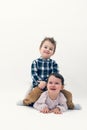 Little toddler boy riding horse on his sister's back isolated Royalty Free Stock Photo