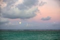 Little toddler boy, sitting on the beach after sunset on a moonlight, enjoying the quiteness of the beach