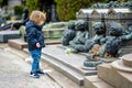 Little toddler boy visiting Cimitero Monumentale di Milano or Monumental Cemetery of Milan, one of the two largest cemeteries in