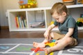 A little toddler boy 2,5 years is playing with a toy helicopter, assembling and disassembling it. Royalty Free Stock Photo
