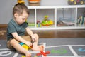 A little toddler boy 2.5 years is playing with a toy helicopter, assembling and disassembling it. Educational toys for kids. Royalty Free Stock Photo