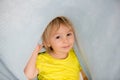 Little toddler boy with yellow shirt, hiding under blanket, smiling Royalty Free Stock Photo