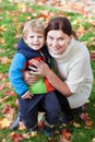 Little toddler boy and young mother in the autumn park Royalty Free Stock Photo