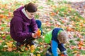 Little toddler boy and young mother in the autumn park Royalty Free Stock Photo