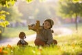 Little toddler child, boy, playing with airplane and knitted teddy bear in autumn park Royalty Free Stock Photo