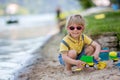 Little toddler child, cute boy, playing with toys in the sand on a lake Royalty Free Stock Photo