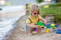 Little toddler child, cute boy, playing with toys in the sand on a lake Royalty Free Stock Photo