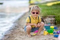 Little toddler child, cute boy, playing with toys in the sand on a lake Royalty Free Stock Photo