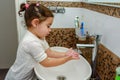 Little toddler girl in bathroom washing hands. Cute sweet baby play in water. Royalty Free Stock Photo