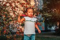 Little toddler girl blowing soap bubbles in summer park. Happy kid playing outdoors Royalty Free Stock Photo