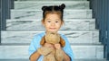 Little toddler girl in blue t-shirt holds brown dog toy Royalty Free Stock Photo