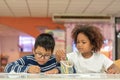 Little toddler girl and boy drawing together.  Asian boy and Mix African girl learn and play together in the pre-school class. Royalty Free Stock Photo