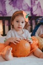 Little toddler girl drawing on a pumpkin making lantern jack on Halloween holiday. Little girl in a carnival costume Royalty Free Stock Photo