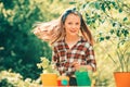 Little toddler girl gardening and having fun in spring yard. Kid planting flowers in pot. Cute little girl watering