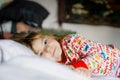 Little toddler girl having fun in bed after wake up. Healthy child jump and play hide and seek with parents. Adorable Royalty Free Stock Photo
