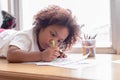 Little toddler girl laying down concentrate on drawing. Mix African girl learn and play in the pre-school class. Children enjoy