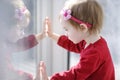 Little toddler girl looking through a window Royalty Free Stock Photo