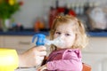 Little toddler girl making inhalation with nebulizer at home. Father or mother helping and holding the device. Child Royalty Free Stock Photo