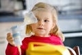 Little toddler girl making inhalation with nebulizer at home. Lovely baby holding the device. Child having flu and cough Royalty Free Stock Photo