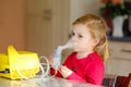 Little toddler girl making inhalation with nebulizer at home. Lovely baby holding the device. Child having flu and cough Royalty Free Stock Photo