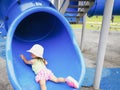 Little toddler girl playing at the slide. Doing an upside-down position Royalty Free Stock Photo