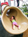 Little toddler girl playing at the slide. Doing upside down position Royalty Free Stock Photo