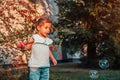 Little toddler girl playing with soap bubbles in summer park. Happy kid having fun outdoors Royalty Free Stock Photo