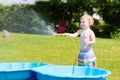 Little toddler girl playing with water hose in the garden Royalty Free Stock Photo