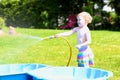 Little toddler girl playing with water hose in the garden Royalty Free Stock Photo