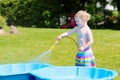 Little toddler girl playing with water hose in the garden Royalty Free Stock Photo