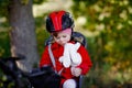 Little toddler girl with security helmet on head sitting in bike seat of her mother or father bicycle. Safe and child Royalty Free Stock Photo