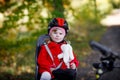 Little toddler girl with security helmet on head sitting in bike seat of her mother or father bicycle. Safe and child Royalty Free Stock Photo
